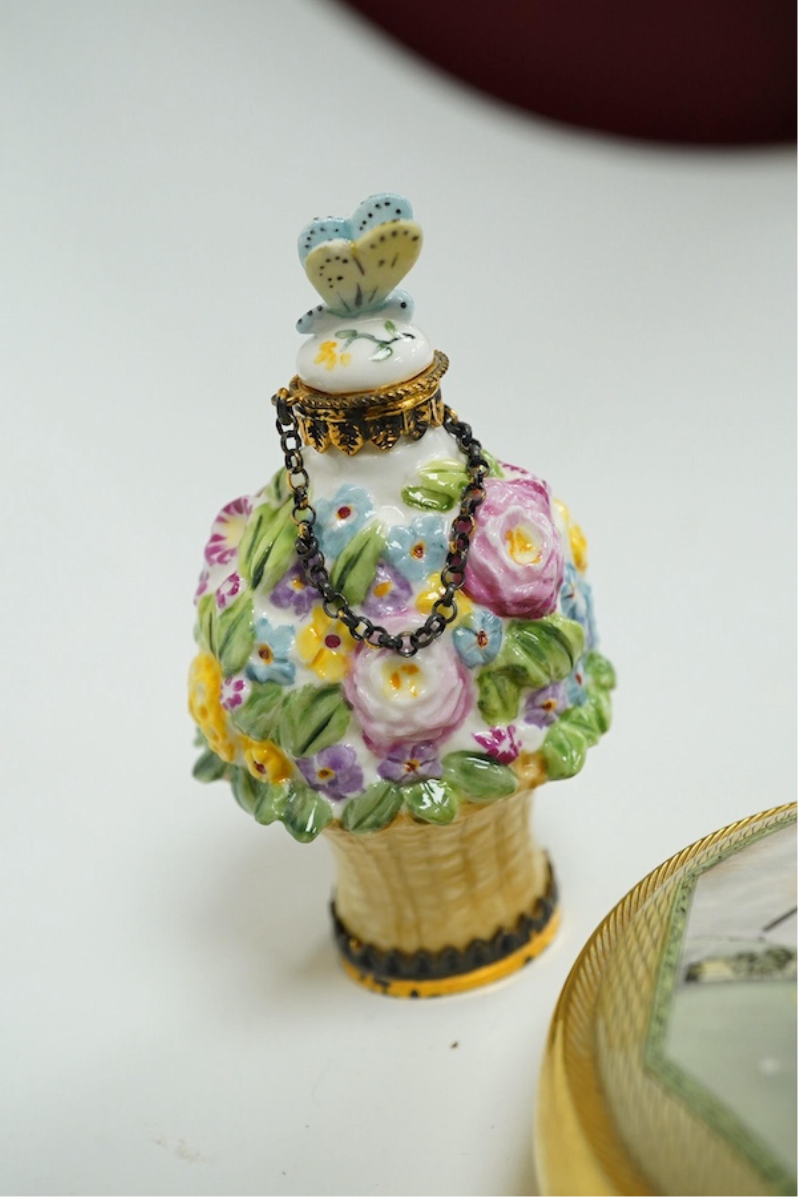 A miniature porcelain egg shaped scent bottle, on chain, two Halcyon Days scent bottles and a circular enamelled paperweight, (4). Condition - fair